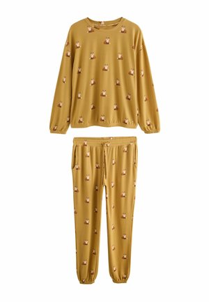 Gelbes Pyjama-Set mit einem Fuchs-Muster. Langärmliges Oberteil mit elastischen Bündchen, passende Hose mit Taschen und elastischem Bund.