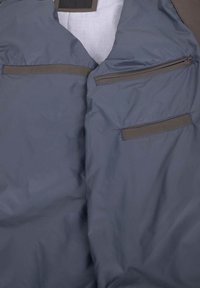 Grau jacke mit glatter textur, zwei reißverschluss-pockets und dunkelbraunen akzenten an den taschenöffnungen.