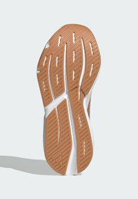 Sportlich Schuhsohle mit einem braunen Gummigriffmuster, das Rillen und Erhebungen für Traktion aufweist. Weiße Zwischensohle mit glatter Oberfläche.