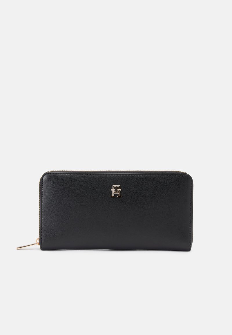 Black leather wallet with a textured surface, gold logo accent, zip closure along the top, and slim rectangular shape.