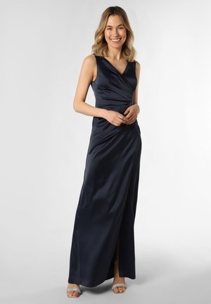 Navy Satin-Abendkleid mit V-Ausschnitt, ärmellosem Design, gerafftem Bund und seitlichem Schlitz. Kombiniert mit glitzernden offenen Sandalen.