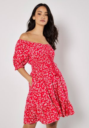 Rotes Blumenkleid mit schulterfreiem Design, Puffärmeln, gerafftem Oberteil und Taschen. Mit weißen Blumenmustern und einem ausgestellten Saum.