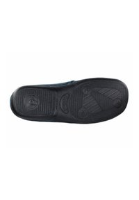 Suela de zapato de goma negra con patrones texturizados y agarres circulares, con un acabado liso y bordes definidos para tracción.