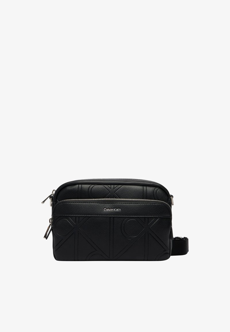 Sac bandoulière noir Calvin Klein avec motif de logo embossé, poche avant zippée et sangle réglable.