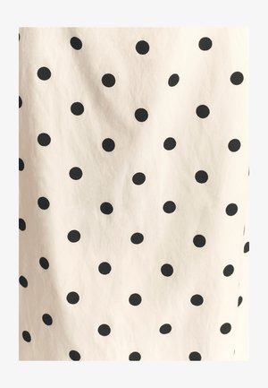 Cotton fabric with a cream background and evenly spaced black polka dots. The texture appears smooth and slightly wrinkled.