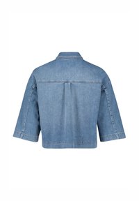 Giacca di jeans con maniche corte, colore azzurro chiaro e design con yoke posteriore. Presenta un colletto classico e cuciture visibili lungo le cuciture.