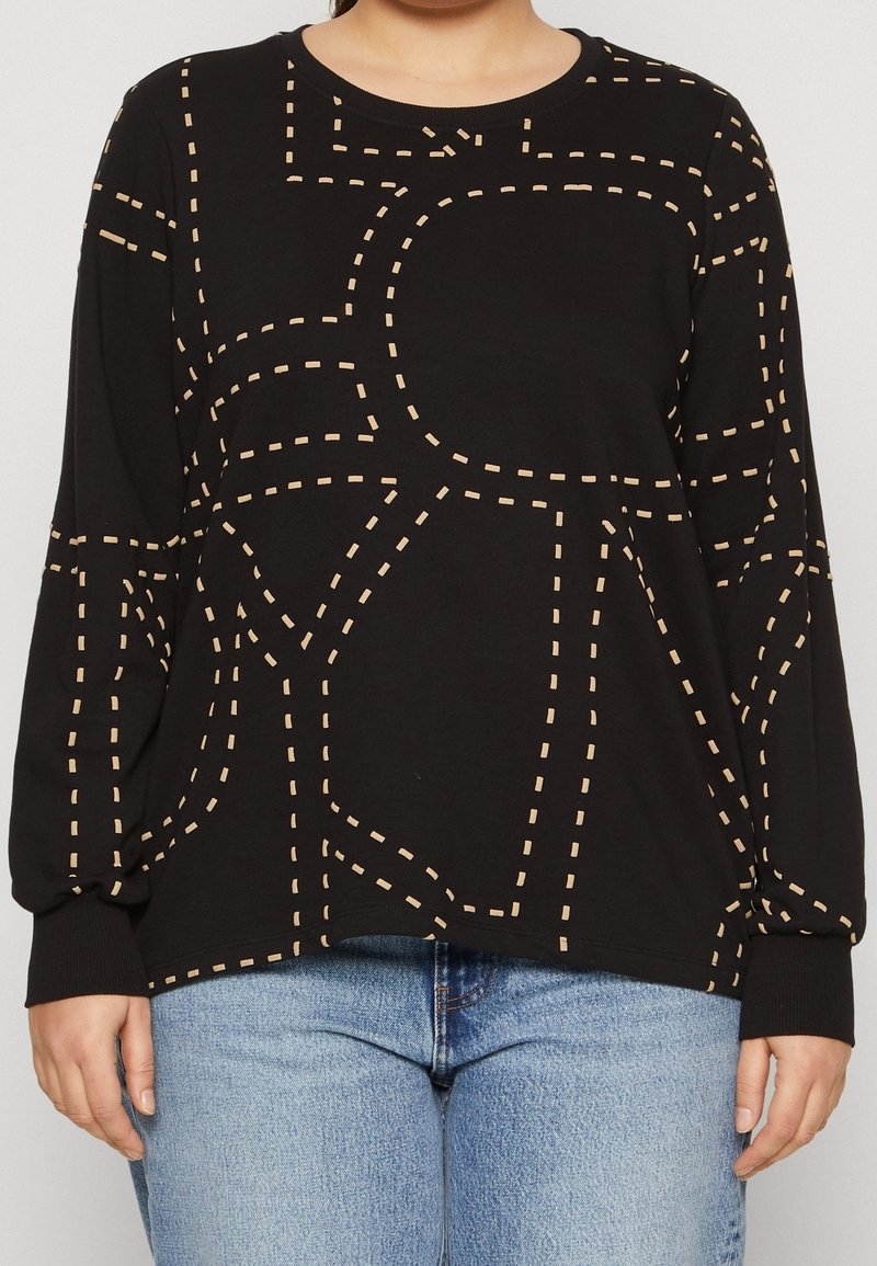 Svart langärmad tröja med ett mönster av krämfärgade streckade linjer, rund halsringning och ribbade ärmslut. Mjuk tyg med bekväm passform.