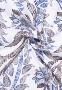 Katoenstof met een bloemenpatroon in tinten blauw en bruin op een witte achtergrond, met gedetailleerde bladeren en een zachte textuur.