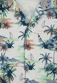 Fehér vászon ing zöld és barna pálmafás és vitorlás hajós mintával, gallérral és fehér gombokkal az elején.