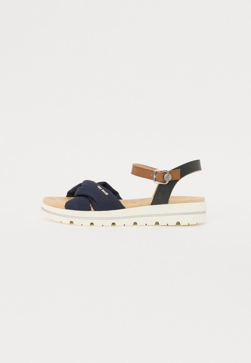 Navy blue fabric sandals with twisted upper design, black adjustable strap, and brown accent. Features a cushioned sole and textured tread.