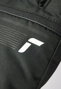 Musta kangaskassi, jossa on sileä pinta valkoisella logolla yhdellä puolella, ja ohuilla vaakasuorilla raidoilla päällä.