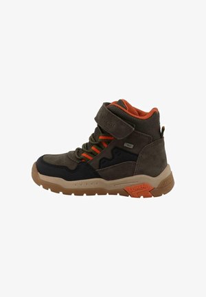 Brown and black mid-top hiking shoe featuring orange accents, Velcro strap, textured surface, and a sturdy rubber sole with grip patterns.