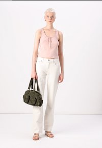 Pink ribbed tank top with button details, white wide-leg jeans, and an olive green shoulder bag with dual front pockets. Beige sandals.