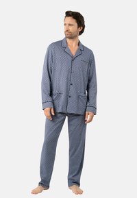 Ensemble de pyjama bleu marine avec des pois blancs, chemise à boutons, pantalon long et tissu doux. Comprend deux poches avant et une poche plaquée.