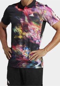 Golfino multicolore con motivo floreale, maniche nere e colletto. Realizzato in tessuto leggero con una texture liscia.