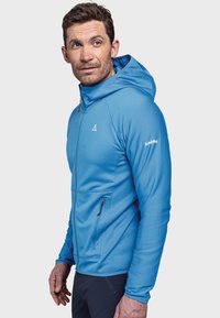 Blaues Zip-Hoodie mit strukturiertem Finish, seitlichen Taschen und taillierter Passform. Verfügt über eine Kapuze und besteht aus leichtem, elastischem Material.