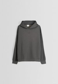 Sudadera con capucha gris hecha de material suave, con un ajuste relajado, puños acanalados y un pequeño logo en relieve en la parte frontal.