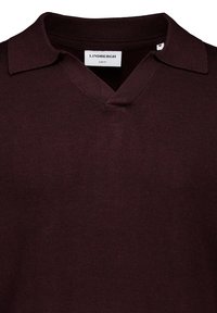 Burgundowa dzianinowa koszulka polo z dekoltem w kształcie litery V i slim fit; posiada płaski kołnierz oraz teksturowany materiał. Metka informuje "Lindbergh."