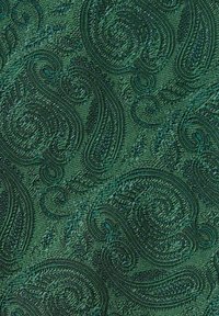 Texturerad grön tyg har ett framträdande paisleymönster med svängande mönster. Materialet verkar vävt och något upphöjt.