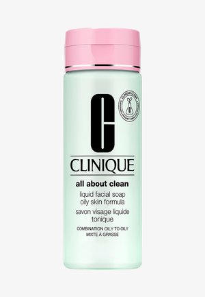 Mintgrøn flaske med et lyserødt låg, mærket "Clinique All About Clean", til olieret hudtype, med sort tekst og logo.