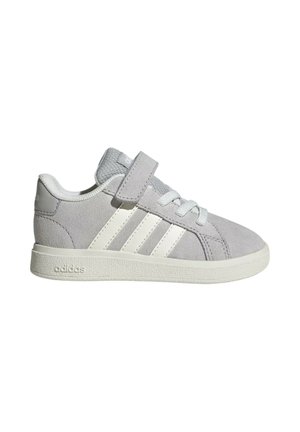 Sneaker in suede grigio con suola in gomma bianca, con lacci e fascia in velcro, caratterizzato da tre strisce bianche sul lato. Design semplice e sportivo.