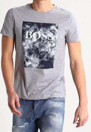 Szara koszulka z krótkim rękawem z granatowym graficznym kwadratem z napisem "BOSS HUGO BOSS". Wykonana z miękkiej bawełny, w luźnym fasonie.