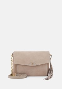 Beżowa zamszowa kopertówka z klapką, złotym łańcuszkiem jako paskiem i detalem w postaci frędzla. Gładka faktura z minimalną ilością metalowych zdobień.