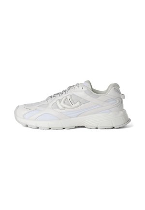 Witte lage atletische sneaker met mesh- en leren panelen, dikke zool, veterluiting en merklogo aan de zijkant.