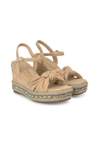 Sandali con zeppa in suede beige, design anteriore annodato, piattaforma decorata con dettagli metallici e suola testurizzata.