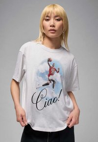 White cotton t-shirt featuring a graphic of a basketball player with "Ciao!" printed in bold, cursive black text below the image.