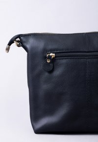 Black leather bag with a textured surface, featuring a front zip pocket and gold-tone hardware, rectangular shape, and soft edges.