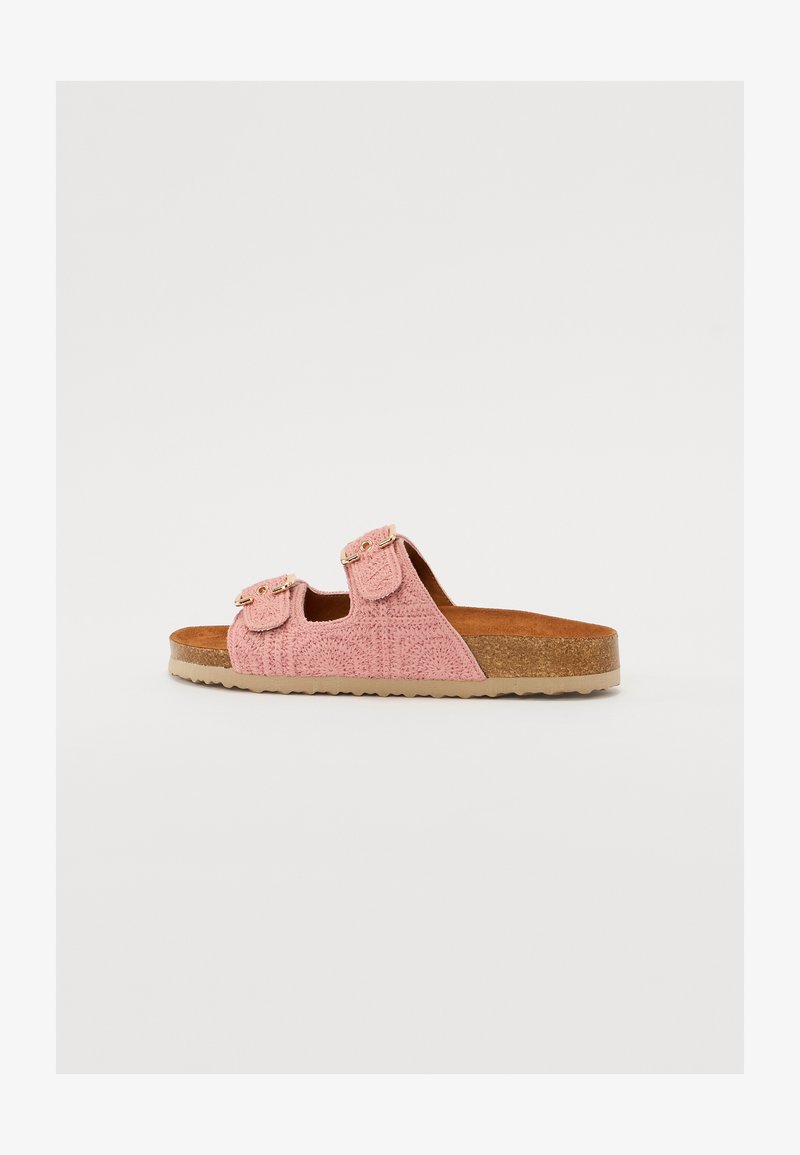 Pink slip-on sandals featuring a textured upper, two adjustable straps with buckles, and a light brown, cushioned cork footbed.