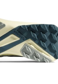 Trail running-sko med sula som har en beige och marinblå design, med texturerad gummi för grepp och vinklade mönster för bättre fäste.