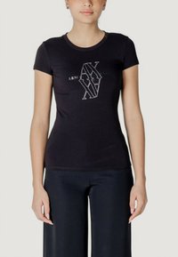 T-shirt nera con design aderente, maniche corte e scollatura rotonda. Presenta un logo grafico bianco al centro. Texture liscia.