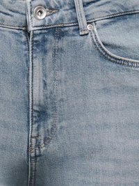 Lähikuva vaaleansinisistä farkuista, joissa näkyy etutasku, vyölenkki, metallinen nappi ja yksityiskohtaiset tikkauskuviot teksturoidulla kankaalla.