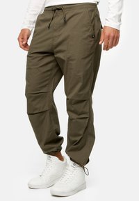 Khaki cargo bukser med elastiske manchetter, justerbar snøre i taljen, forlommer og sidelommer, lavet af letvægtsstof.