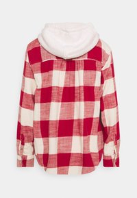 Red and white plaid flannel shirt with a soft white hood. Features long sleeves, button cuffs, and a curved hem. Cotton fabric texture.