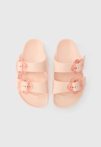 Růžové sandály se dvěma nastavitelnými pásky a sponami ve tvaru květin. Vyrobené z hladkého plastu s tvarovanou stélkou pro pohodlí.