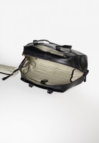 Schwarzer Leder-Rucksack mit Reißverschluss, ausgestattet mit einem beigen Innenfutter und Innenfächern. Beinhaltet verstellbare Riemen und einen oberen Griff.