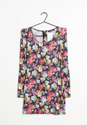Robe à manches longues à motif floral sur un cintre, avec un fond sombre et des fleurs multicolores, un col rond et une étiquette accrochée.