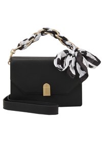 Bolso de mano de cuero negro texturizado con un cierre dorado, una cadena como asa y una bufanda de seda con un patrón en blanco y negro atada en el asa.