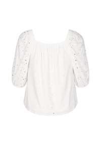 Camicia bianca in cotone ricamato, con scollo a quadrato, maniche a sbuffo e motivi ad occhiello in tutto il capo. Texture caratterizzata da cuciture arricciate.