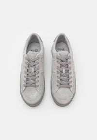 Gray suede sneakers with a smooth texture, featuring lace-up design, reinforced toe cap, and subtle branding on the tongue.