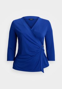 Blue wrap top made of smooth fabric, featuring a V-neck, three-quarter sleeves, and a decorative gold accent on the side knot.