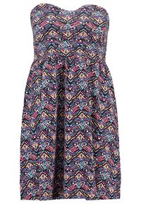 Robe sans bretelles présentant un motif géométrique multicolore, fabriquée en tissu léger avec un design fluide et un bustier élastique.