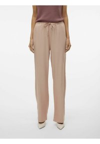 Pantalons rose clair, amples, avec une taille à cordon de serrage et des détails en métal. Le tissu semble doux, fluide et lisse.
