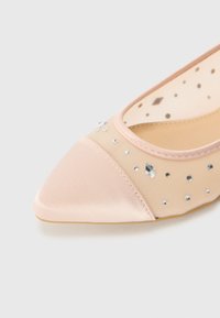 Pantofii plat din satin roz pal, cu vârf ascuțit, laterale din plasă și cristale decorative. Textură fină, design elegant, construcție ușoară.