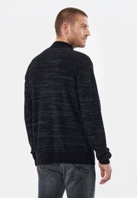 Pull en maille noir avec une finition texturée, doté d'un col rond et de poignets côtelés. Le design comprend de subtils rayures grises.