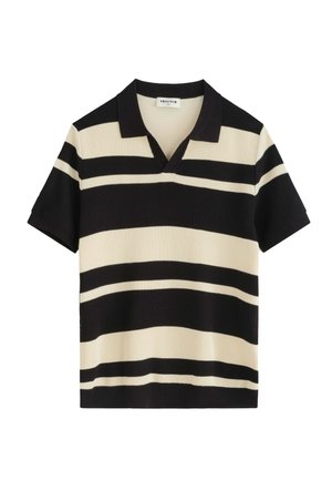 Polo en maille à manches courtes avec des rayures horizontales noires et crème et un col noir, posé à plat sur fond blanc.