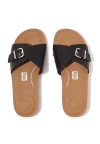 Zwarte slidesandalen met een brede band en een gouden gesp. De voetbed is bruin met een gladde textuur en logo-details.